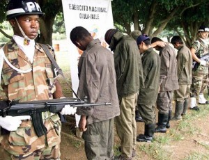 In the first two months of 2014, 43 children escaped or were rescued from illegal armed organizations in Colombia after 332 deserted in all of 2013, according to the Ministry of Defense. Above, alleged members of illegal armed groups, including four minors, were watched by Colombian Military Police in Cali on April 7, 2013. (Mauricio Dueñas/AFP)